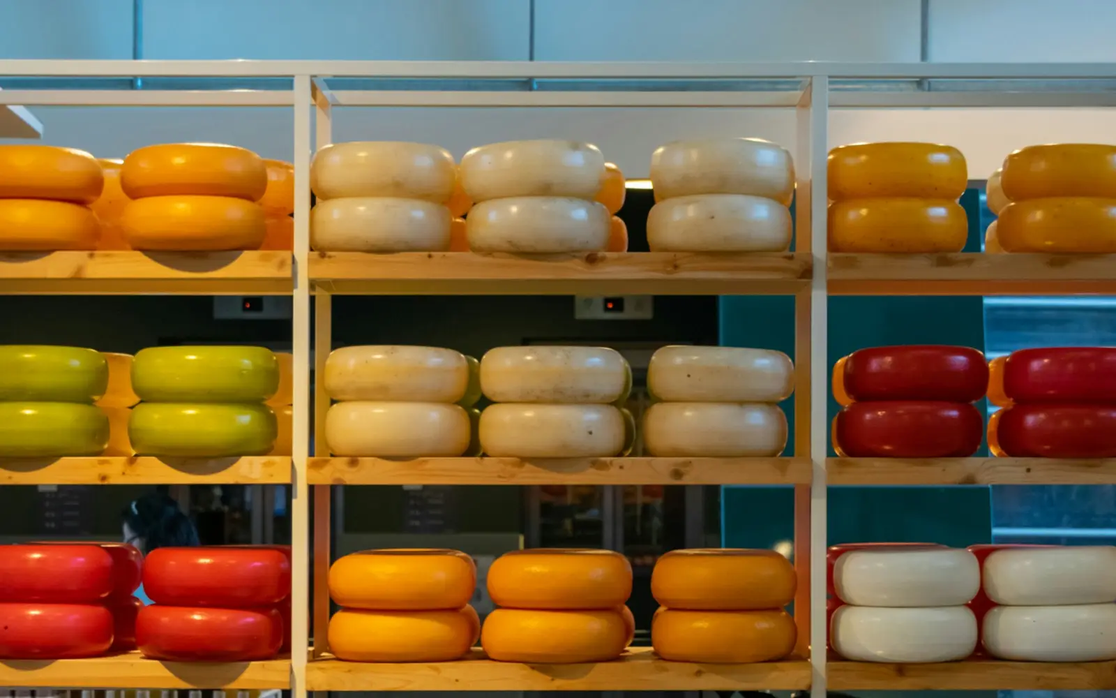 Schappen vol kazen in geel, wit, groen en rood
